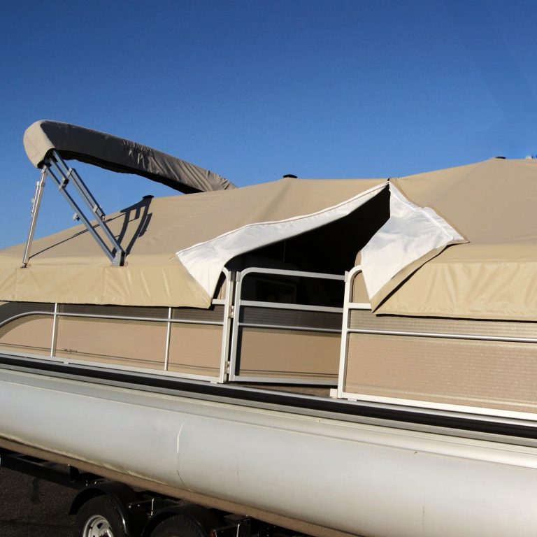 A boat's cockpit with a clear canopy, fabric items, and moored boats in the background.